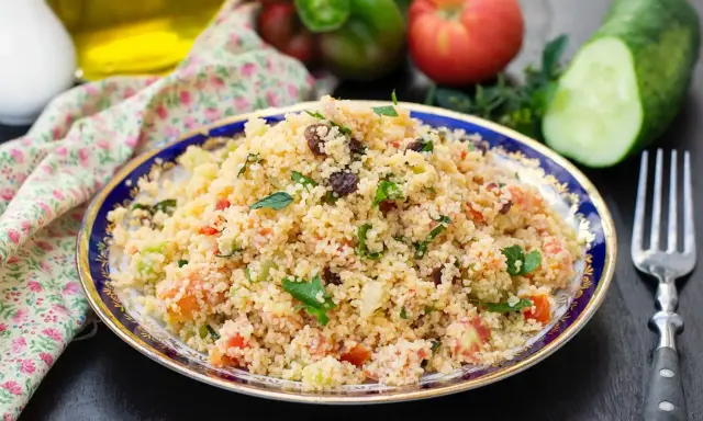 Taboulé coloré avec poivron, tomates, concombre et raisins secs. Une recette fraîche et savoureuse.