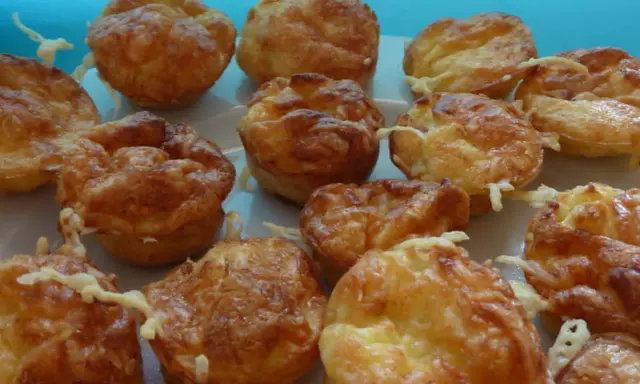 Une assiette de mini quiches sans pâte dorées et appétissantes, garnies de fromage fondu. Parfaites pour un apéritif gourmand.