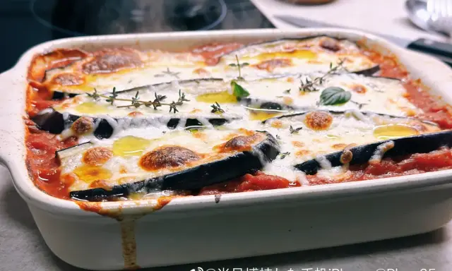 Plat gratiné de poulet et aubergine au four, nappé de sauce tomate et fromage fondant, garni de thym frais. Un délice pour votre recette poulet aubergine au four.