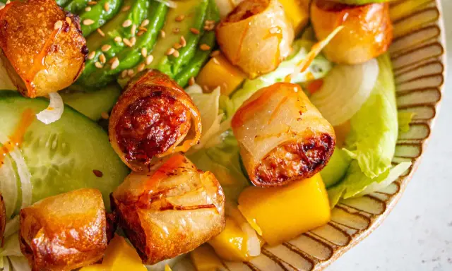 Rouleaux croustillants, avocat, mangue et concombre sur un lit de laitue. Une recette street food colorée et savoureuse.