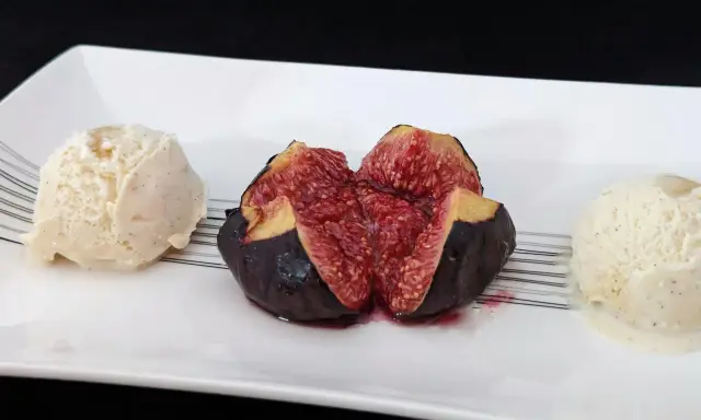 Une figue fraîche coupée en deux, servie avec deux boules de glace à la vanille. Un aperçu des 15 recettes étonnantes à la figue fraîche.