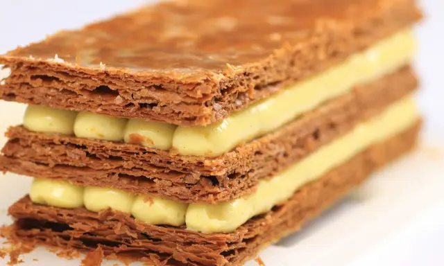 Un millefeuille croustillant aux couches de pâte feuilletée dorée et de crème pâtissière onctueuse. Une recette de mille feuille qui fait rêver.