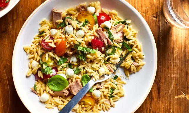 Salade de pâtes orzo avec thon, tomates cerises, billes de mozzarella et basilic frais, parfaite pour un pique-nique ensoleillé.