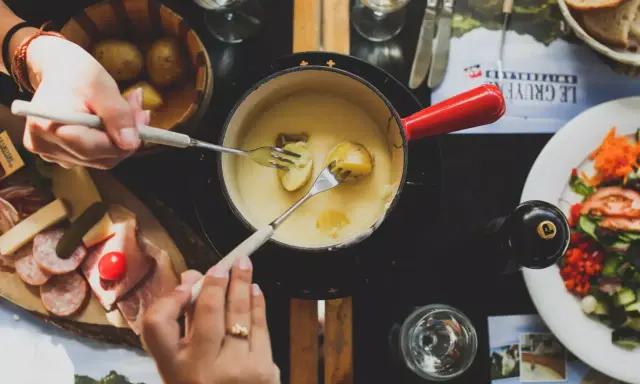 Un délicieux vin blanc pour fondue savoyarde accompagne ce plat réconfortant. Des pommes de terre et du fromage fondent dans le caquelon.