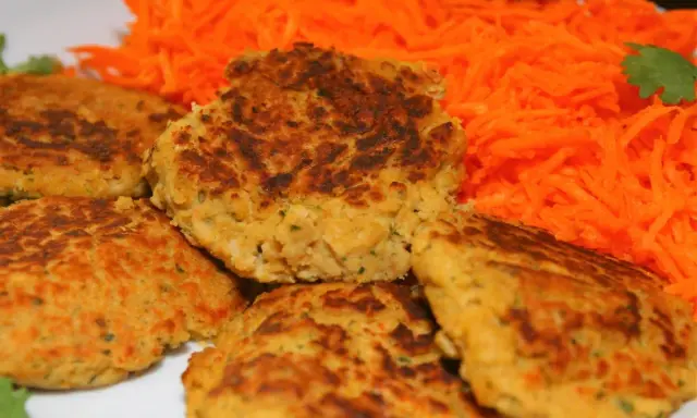 Galettes de pois chiche dorées et croustillantes, servies avec une généreuse portion de carottes râpées fraîches. Un délice végétarien !