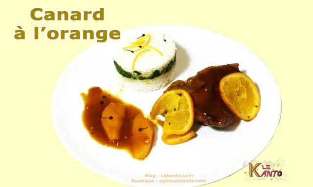 Un plat de canard à l'orange, avec du riz et des quartiers d'orange.