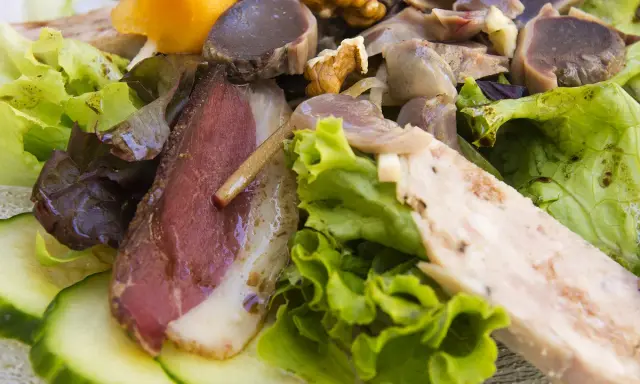 Salade landaise généreuse avec magret de canard fumé, gésiers confits, noix et légumes croquants. Un délice du Sud-Ouest.