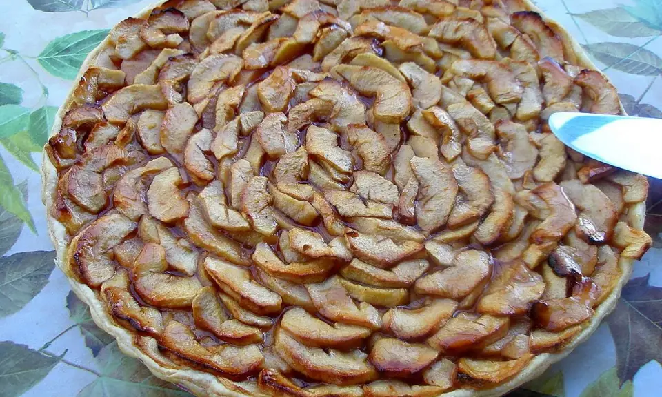 Tarte aux pommes et coings, dorée et appétissante, prête à être dégustée.