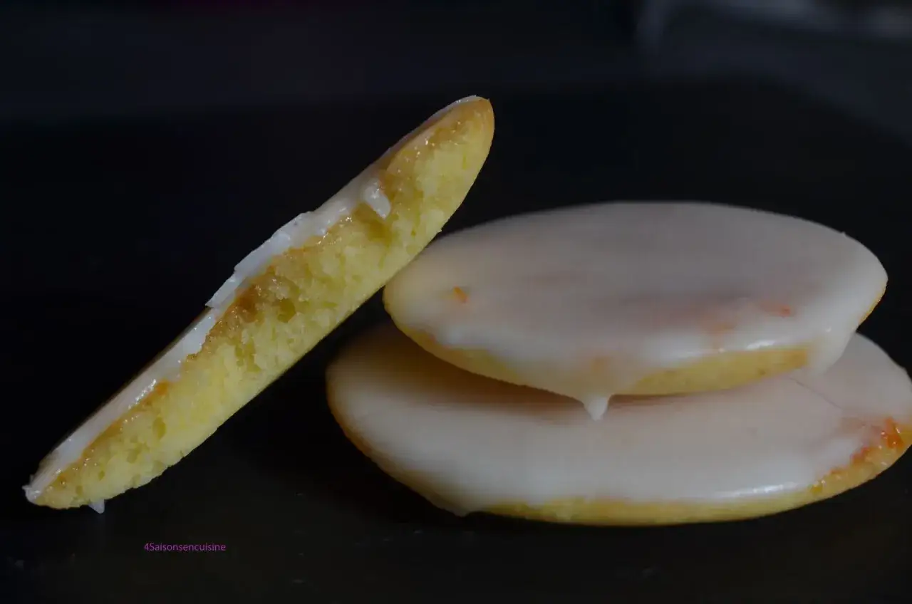 Deux palets de dame glacés, l'un posé sur l'autre, un autre coupé en deux, révélant sa texture moelleuse.