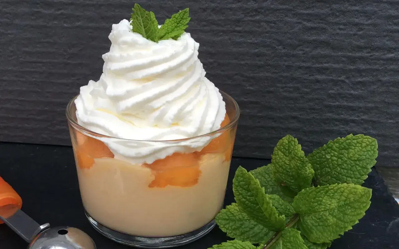 Verrine melon dessert rafra&icirc;chissante, garnie de chantilly et d'une touche de menthe.