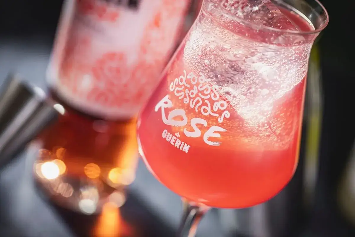Un cocktail rosé pétillant, un verre de Pineau des Charentes Guérin, prêt à être dégusté.