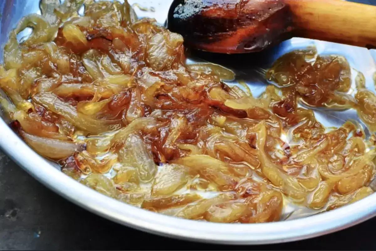 Oignons nouveaux caramélisés dans une poêle, prêts pour une délicieuse recette.