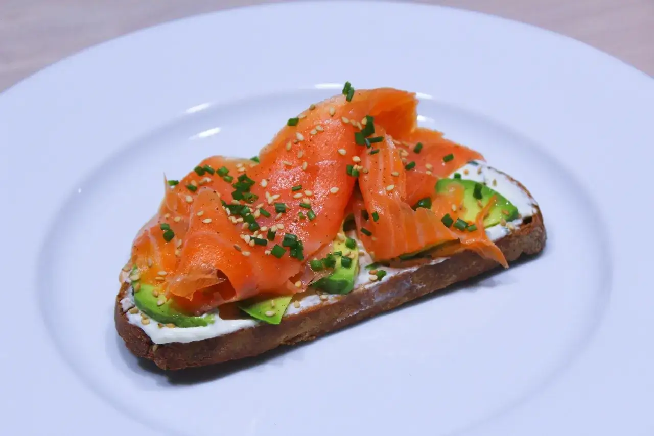 Un toast gourmand avec avocat, saumon fum&eacute;, fromage frais, parsem&eacute; de graines de s&eacute;same et ciboulette.
