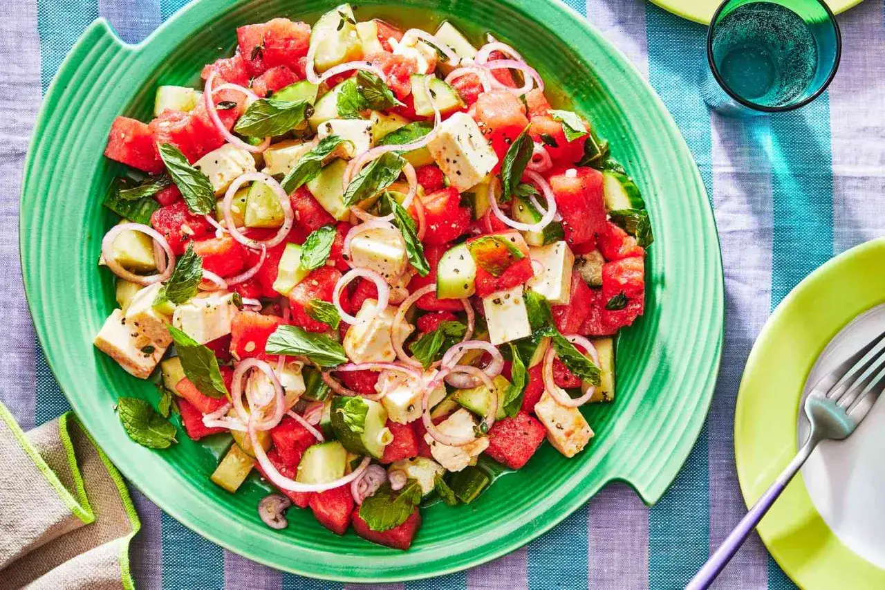 Salade estivale colorée : cubes de pastèque, melon, concombre, feta, oignons rouges et menthe fraîche.