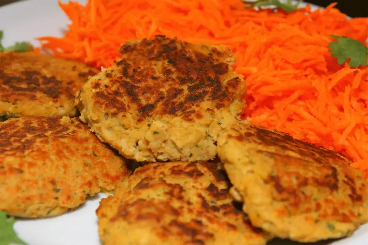 Galettes de pois chiche dor&eacute;es, croustillantes &agrave; l'ext&eacute;rieur, moelleuses &agrave; l'int&eacute;rieur, servies avec une g&eacute;n&eacute;reuse portion de carottes r&acirc;p&eacute;es.