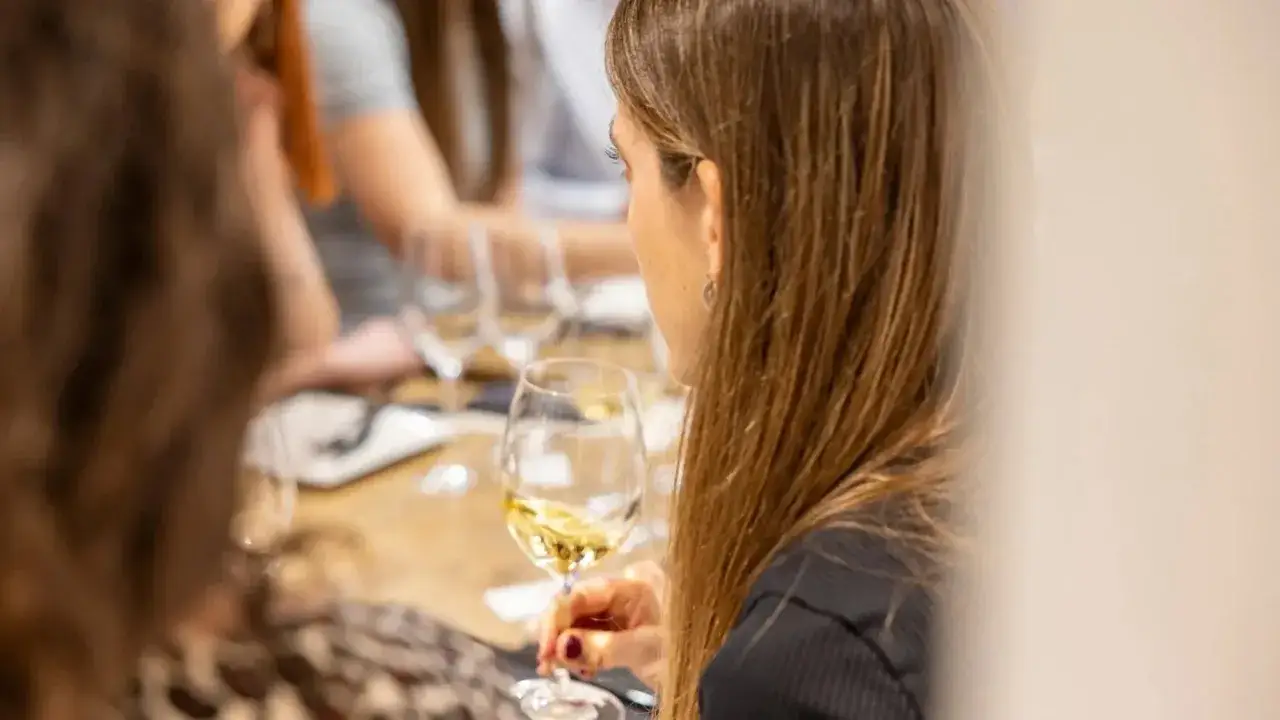 Une femme déguste un verre de vin blanc beurré lors d'une dégustation.