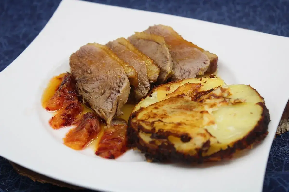Tranches de canard à l'orange, accompagnées de quartiers de pommes de terre rôtis et d'une sauce fruitée. Un délice !