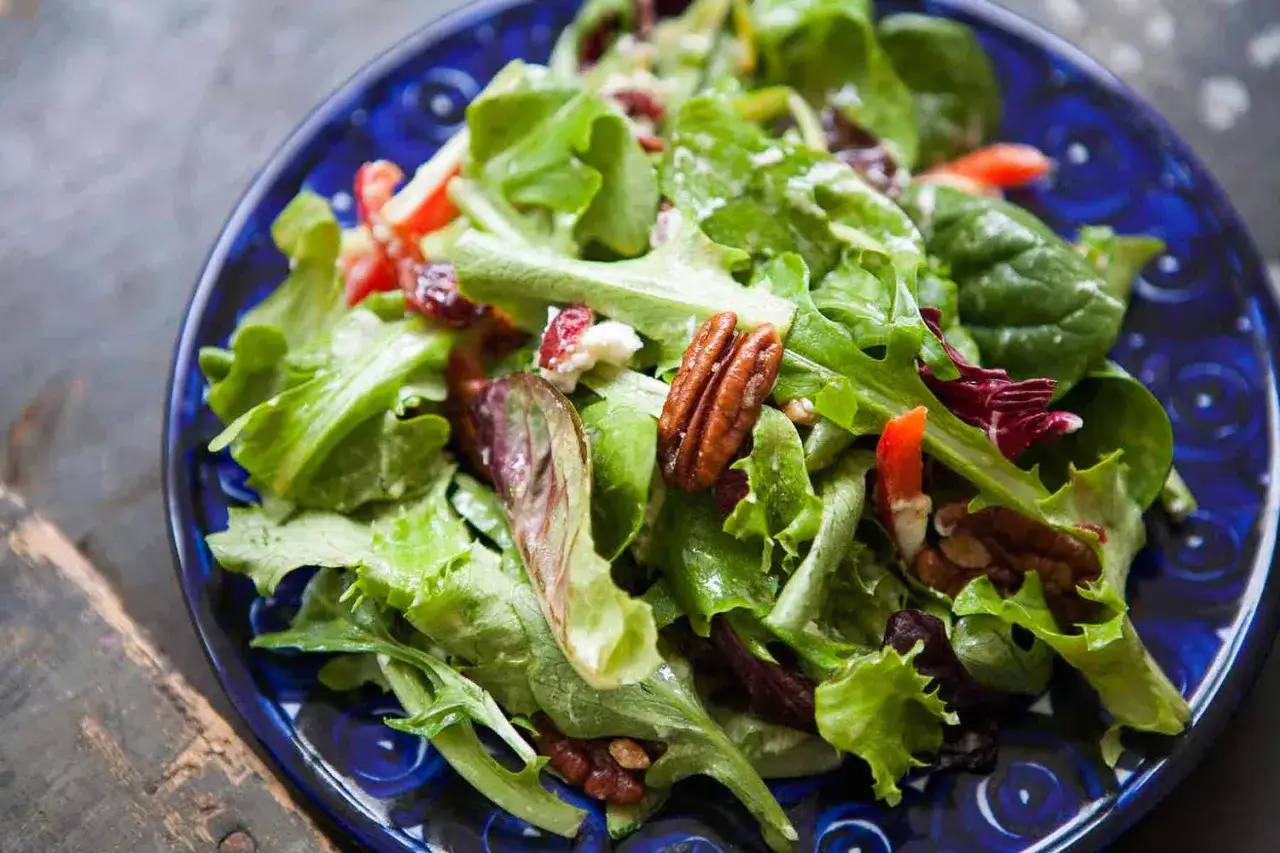 Salade verte fraîche avec noix de pécan, fromage et fruits secs. Une recette légère et savoureuse.