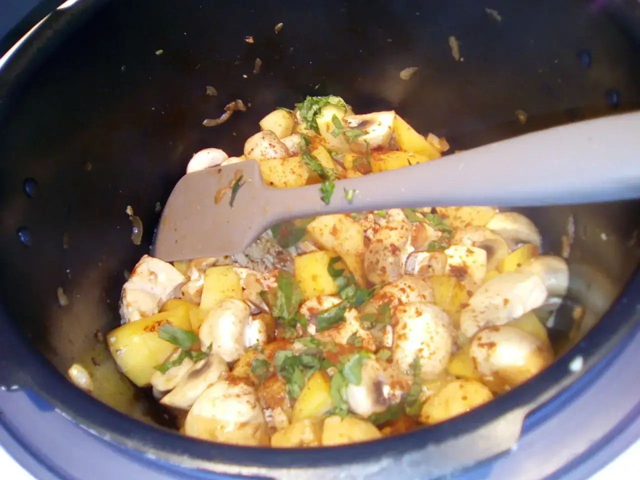 Pr&eacute;paration d'un poulet &agrave; la cr&egrave;me fa&ccedil;on grand-m&egrave;re : morceaux de poulet, pommes de terre et champignons mijotent dans une cocotte.