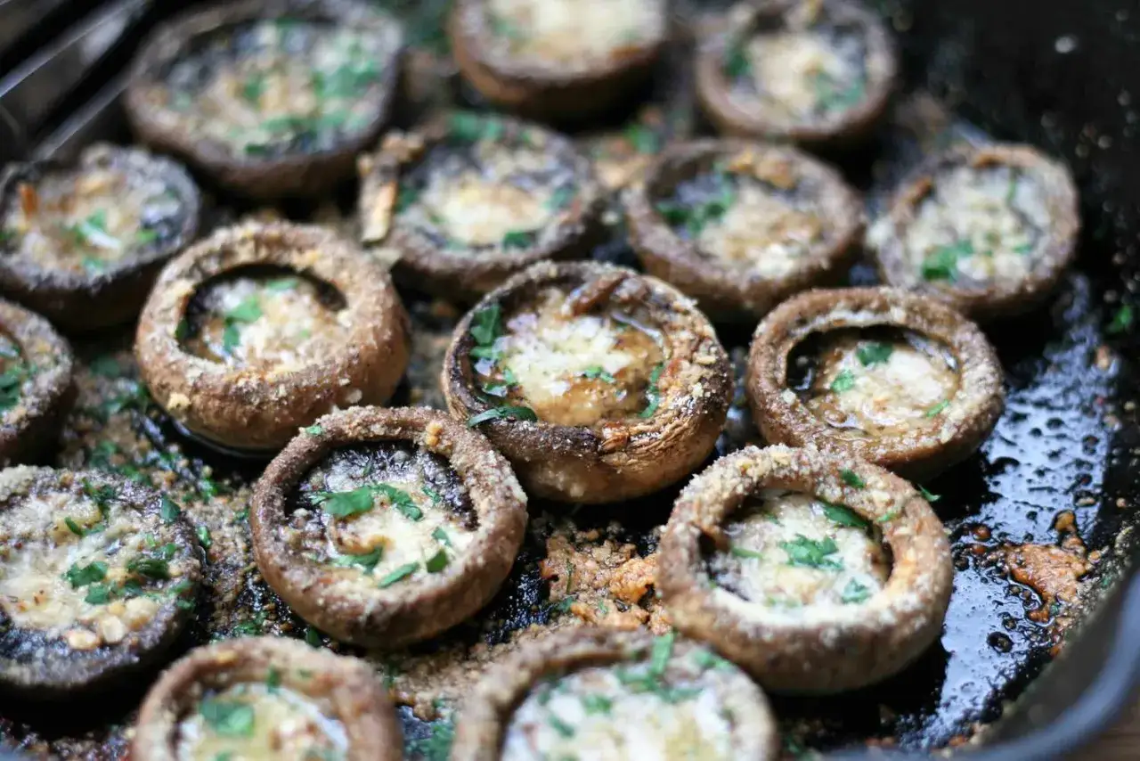 Champignons de Paris farcis au fromage et persil, prêts à être dégustés. Une recette simple et savoureuse.