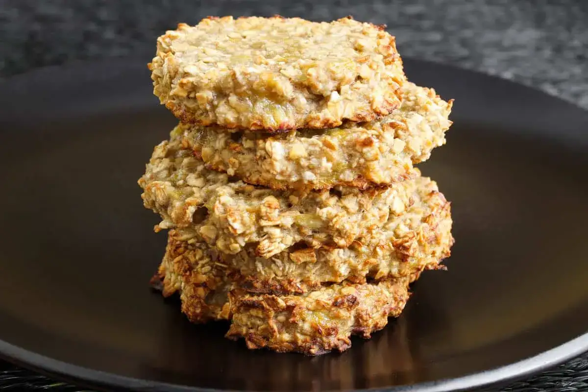 Pile de d&eacute;licieux cookies healthy flocons d'avoine, dor&eacute;s et app&eacute;tissants, sur une assiette noire.