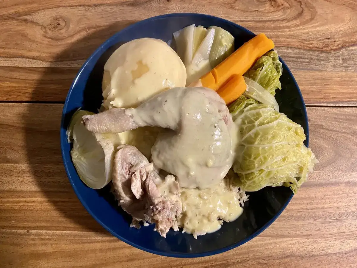 Plat réconfortant de poule au pot façon grand-mère : poulet, purée, riz, carottes, poireaux et chou savoyard nappés d'une sauce crémeuse.