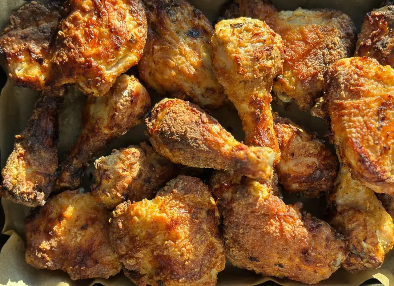 Un assortiment de morceaux de poulet frit, dorés et croustillants, prêts à être dégustés.