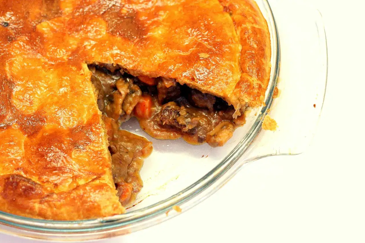 Une tourte à la viande grand-mère dorée et appétissante, avec une croûte croustillante et une garniture généreuse de viande et de légumes.
