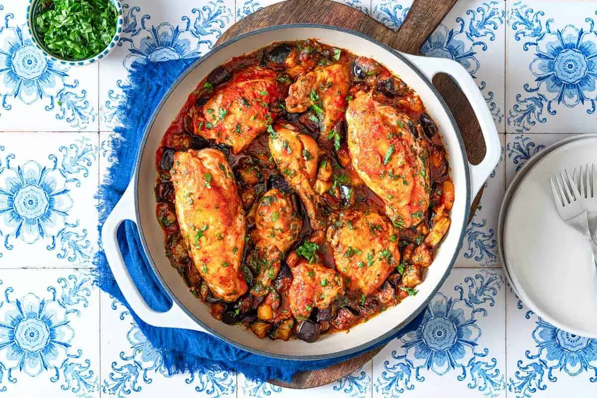 Un plat appétissant de recette poulet aubergine au four, garni de persil frais, prêt à être dégusté.