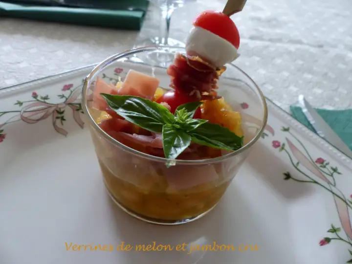 Verrine melon jambon cru : dés de melon, jambon cru, mozzarella et tomate cerise sur un pic. Une feuille de basilic décore ce délice.